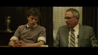 Two men talking at table with microphone — The Social Network