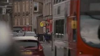 Man in suit walking on street — Succession