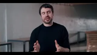 Man with beard gesturing in empty concrete room — The Social Dilemma