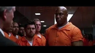 men in orange prison uniforms in hallway — Batman: The Dark Knight