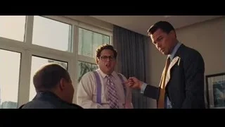 Three men conversing, one speaking into microphone — The Wolf Of Wall Street