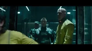 Three men in dimly lit room with glass door — Deadpool 2
