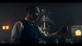 young man holding scissors in dimly lit bar — Peaky Blinders