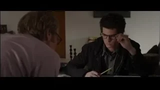 Young man writing in notebook at table — The Amazing Spider Man