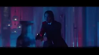 Man in suit holding gun in dark room — John Wick