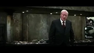 elderly man in suit walking in concrete room — Batman: The Dark Knight