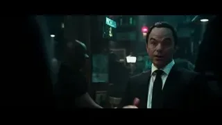man in suit standing in dimly lit bar — Deadpool