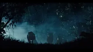 two people riding motorcycles in forest at night — Jurassic World