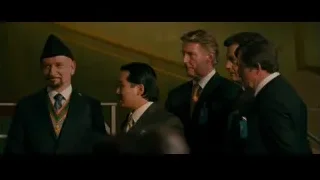 four men in room with staircase and medal — The Dictator