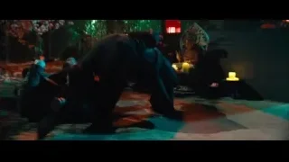 man kneeling holding gun in dim room — John Wick: Chapter 4
