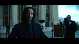 Hand reaching for playing cards on table — John Wick: Chapter 4