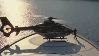 Black helicopter flying over water — Succession