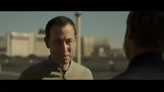 two men conversing with cityscape background — F1
