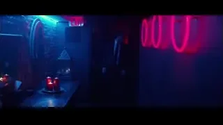Men in suits talking in neon-lit hallway — John Wick