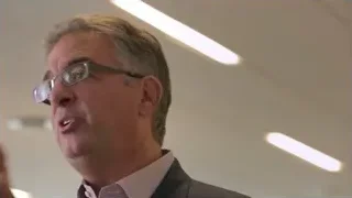 man with glasses speaking into microphone — Screened Out
