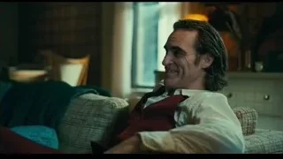 man with dark hair sitting on couch — Joker