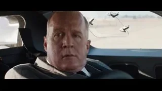 man in car driver's seat with serious expression — Ford v Ferrari