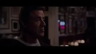man in dimly lit room with neon sign — Creed