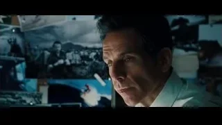 man looking at wall of photographs — The Secret Life of Walter Mitty