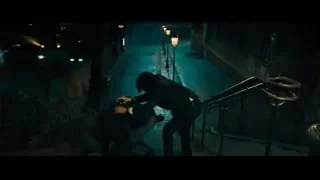 person walking down street holding gun at night — John Wick: Chapter 4