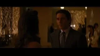 man in suit talking to woman in dim room — Batman: The Dark Knight Rises