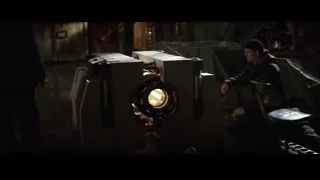 man in beanie by large machine in dim room — Batman