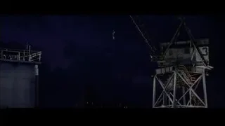 person hanging from crane on tall tower — Spider Man 2
