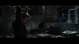 Man holding metal rod in cluttered room — Iron Man 3