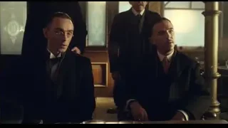 two men sitting at table in dimly lit room — Peaky Blinders