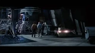 Workers in dark industrial room with large structure — Interstellar