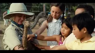 children and woman interacting with dinosaur — Jurassic World