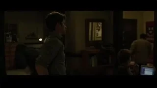 young man with head in hands in dim room — The Social Network
