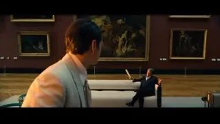 Man in suit on couch in art gallery — John Wick: Chapter 4