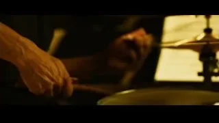person's hand playing drum set in dim room — Whiplash