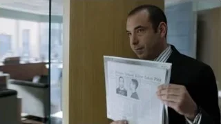 Man in suit standing by window with cityscape — Suits