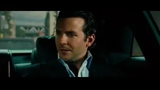 man in suit sitting in car with cityscape — Limitless