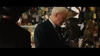 Elderly man in store examining small object — Now You See Me