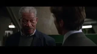 two men talking by green wall — Batman