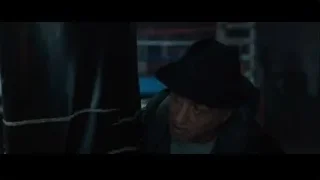 man in black fedora in dim room — Creed 2