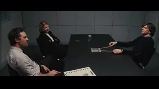 three people at table with handcuffs — Now You See Me