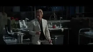Man in beige suit in dimly lit room — Iron Man 3