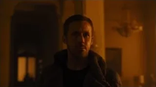 Man in dimly lit living room with chandelier — Blade Runner 2049