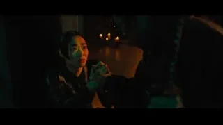 Young woman praying in candlelit room — John Wick: Chapter 4
