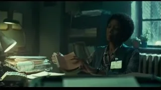 woman sitting at a desk in a dimly lit office — Joker