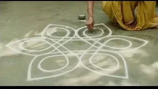 woman in yellow saree drawing rangoli — Life of Pi