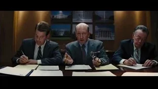 three men, one bald, gesturing in meeting room — The Wolf Of Wall Street