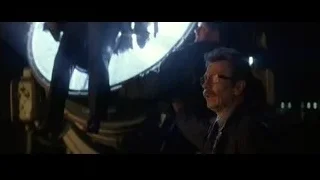 Man in dimly lit room with city skyline — Batman