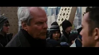 older man in black coat talking to people — Batman: The Dark Knight Rises