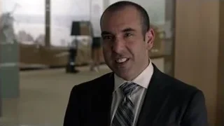 bald man in suit in office lobby — Suits