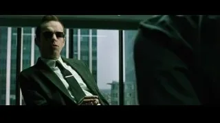 Man in suit and sunglasses by city window — The Matrix